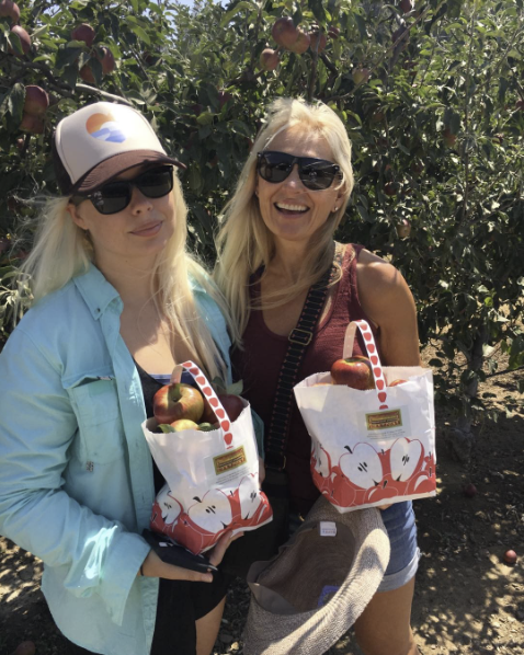 Two happy visitors with their full apple bags